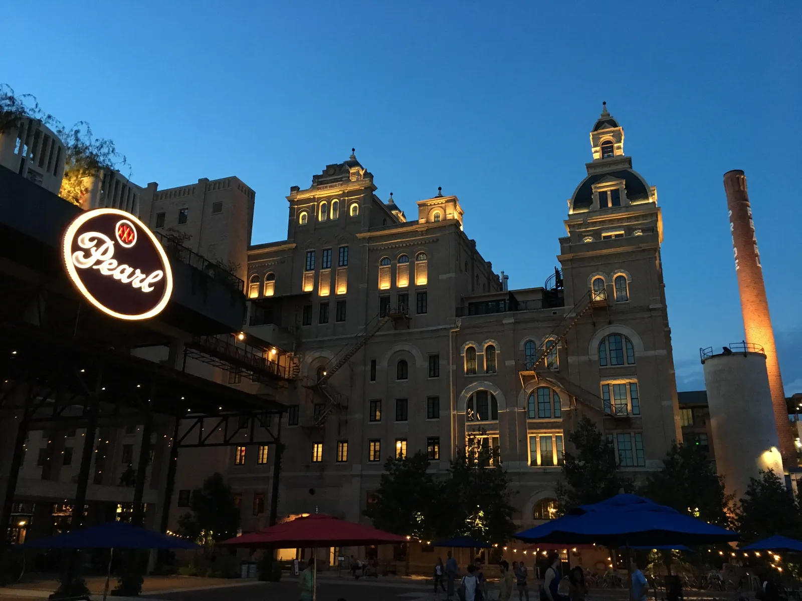 The historic Pearl Brewery building lit up at dusk in San Antonio's Pearl district
